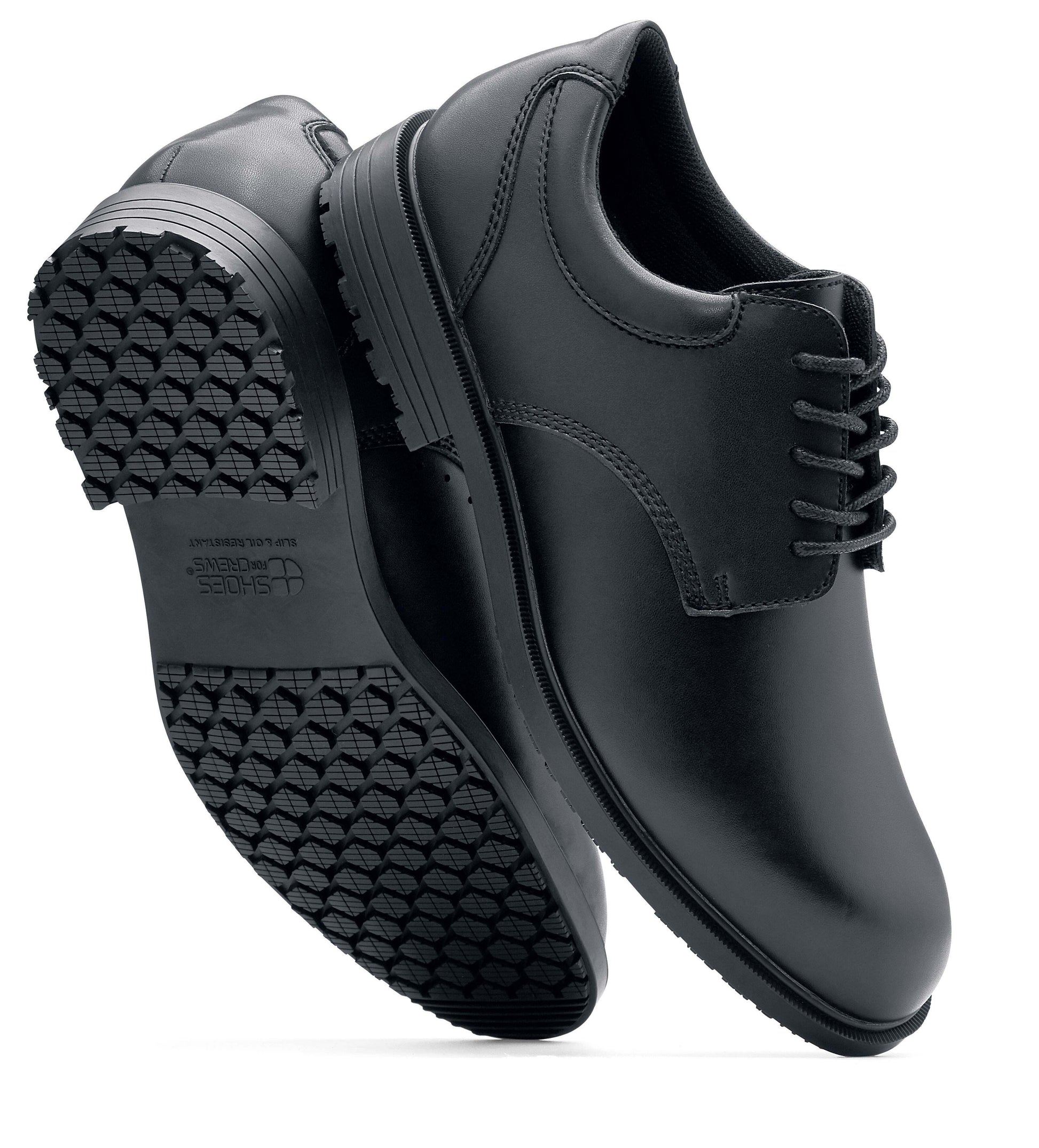 The Shoes for Crews Cambridge III is a slip-resistant leather dress shoe, with removable cushioned insoles and a padded comfort collar, pair viewed vertically, with a focus on the sole and side.